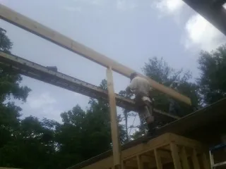 Carpenter setting a ridge beam over a new addition frame — Ice Dam Removal by Roofing Brothers in Catlett