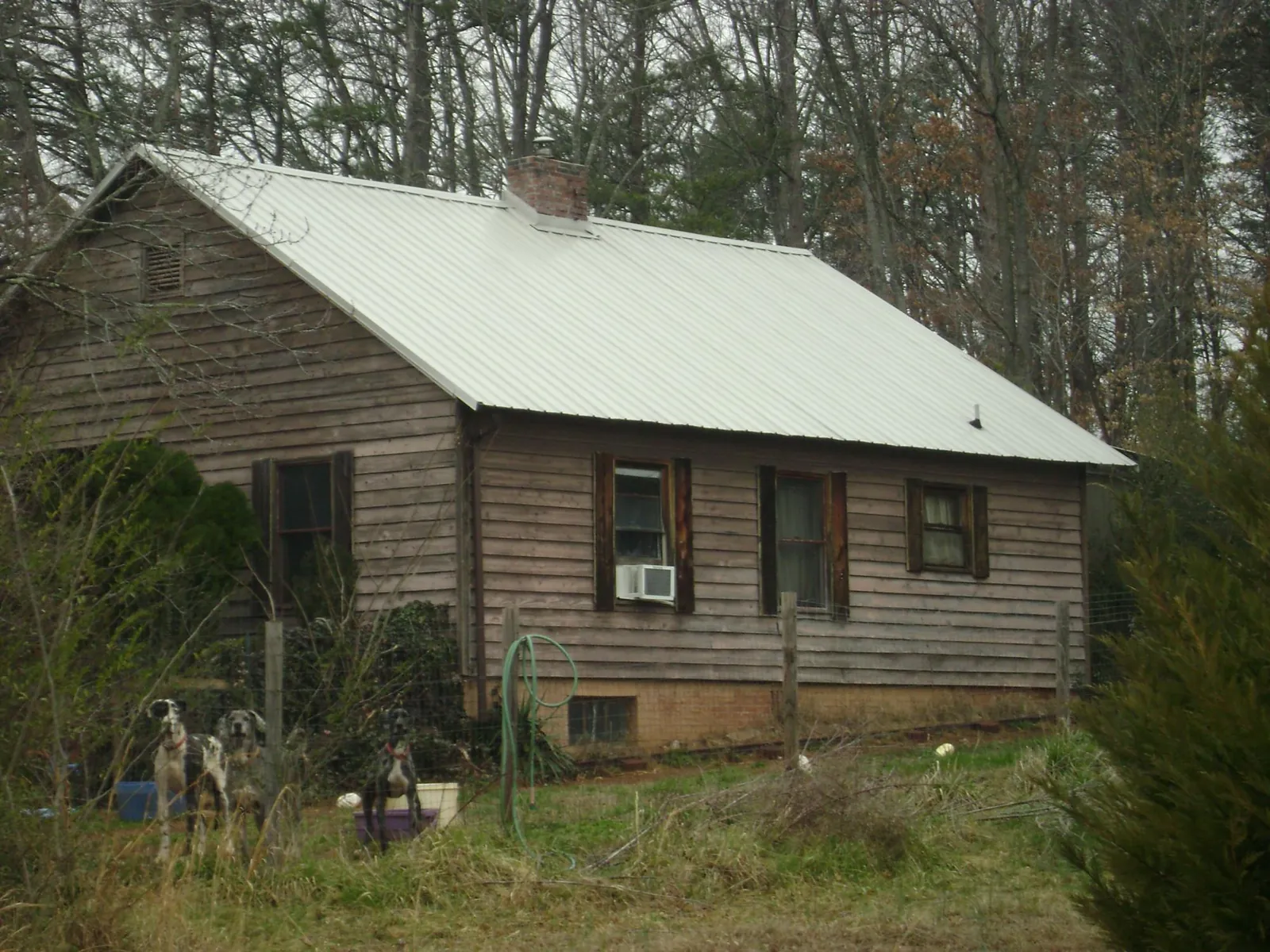 White metal roof on an old wood sided farmhouse, from a Asphalt Shingle Roof Repair job in Catlett